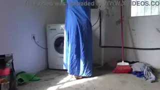 خادمة مسلمة هي لعبة الكلب أثناء القيام بغسيل الملابس